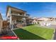 Inviting backyard featuring a covered patio with seating, artificial turf, and a gravel area with chairs around a fire pit at 11679 W Parkway Ln, Avondale, AZ 85323