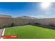 Spacious backyard with artificial turf and a block wall fence, offering a blank canvas for outdoor enjoyment at 11679 W Parkway Ln, Avondale, AZ 85323