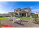Expansive backyard with a covered patio, artificial turf, gravel area with seating, and a partial view of the home's exterior at 11679 W Parkway Ln, Avondale, AZ 85323