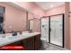 Well-lit bathroom with a modern vanity, sleek mirror, and glass-enclosed shower at 11679 W Parkway Ln, Avondale, AZ 85323