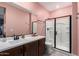 Modern bathroom with a sleek vanity, stylish mirror, and a glass-enclosed shower for contemporary living at 11679 W Parkway Ln, Avondale, AZ 85323