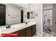 Bright bathroom featuring a double sink vanity, framed mirror, and decorative dinosaur artwork at 11679 W Parkway Ln, Avondale, AZ 85323