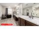 Bright bathroom featuring dual sinks and wood-look tile flooring at 11679 W Parkway Ln, Avondale, AZ 85323