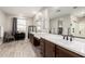 Bright bathroom with double vanity sinks, wood-look flooring, and natural light at 11679 W Parkway Ln, Avondale, AZ 85323