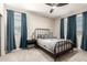 Comfortable bedroom with a black metal bed frame, ceiling fan and natural lighting at 11679 W Parkway Ln, Avondale, AZ 85323