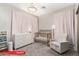 Charming Bedroom with crib, chair, and dresser beneath an elegant chandelier at 11679 W Parkway Ln, Avondale, AZ 85323