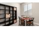 Cozy dining area with shelving unit, chairs, and natural lighting from a window at 11679 W Parkway Ln, Avondale, AZ 85323