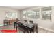 Bright dining room with wood-look tile flooring, large windows, and a modern black dining table at 11679 W Parkway Ln, Avondale, AZ 85323
