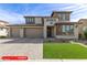 Two-story home features a well manicured front yard, three-car garage, and neutral color palette at 11679 W Parkway Ln, Avondale, AZ 85323