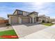 Two-story home exterior with a well manicured lawn, three-car garage, and neutral color scheme at 11679 W Parkway Ln, Avondale, AZ 85323