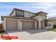 Two-story home with a neutral color palette featuring a three-car garage and drought-resistant landscaping at 11679 W Parkway Ln, Avondale, AZ 85323