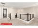 Bright hallway with modern railings and neutral carpet for a contemporary and welcoming home at 11679 W Parkway Ln, Avondale, AZ 85323