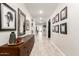 Hallway with wood-look tile flooring, decorative console table, mirror, and wall art at 11679 W Parkway Ln, Avondale, AZ 85323