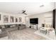 Bright living room with ceramic tile floors, modern fan, large sectional, and media center at 11679 W Parkway Ln, Avondale, AZ 85323