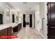 Spacious main bathroom featuring dual sinks, wood-look tile flooring and a walk-in shower at 11679 W Parkway Ln, Avondale, AZ 85323