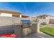 Outdoor kitchen features a built-in grill, counter space, and manicured backyard at 11679 W Parkway Ln, Avondale, AZ 85323