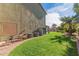 Large backyard featuring green grass, mature palm trees, and essential home utilities neatly arranged at 12443 W Monte Vista Rd, Avondale, AZ 85323