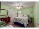 Cozy bedroom with carpet, green walls, ceiling fan, and a comfortable bed with patterned bedding at 12443 W Monte Vista Rd, Avondale, AZ 85323