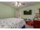 Well-lit bedroom with green walls featuring a ceiling fan and a TV for relaxing at 12443 W Monte Vista Rd, Avondale, AZ 85323