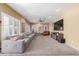 Spacious living room featuring a large gray sofa, ceiling fan, and a modern entertainment center at 12443 W Monte Vista Rd, Avondale, AZ 85323