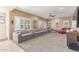 Bright and airy living room with a huge sofa, plantation shutters, and a cozy seating area at 12443 W Monte Vista Rd, Avondale, AZ 85323