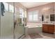 Main bathroom with a walk-in shower, soaking tub, and shutters at 12443 W Monte Vista Rd, Avondale, AZ 85323