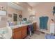 Bright main bathroom with a large vanity, expansive mirror, and natural light at 12443 W Monte Vista Rd, Avondale, AZ 85323