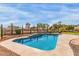 Inviting in-ground pool area with stylish landscaping and a calming waterfall feature at 12443 W Monte Vista Rd, Avondale, AZ 85323