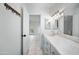 Bright bathroom with dual sinks, mirror, and view to bedroom at 1428 E Las Palmaritas Dr, Phoenix, AZ 85020