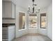 Eating area with bright lighting fixture, neutral flooring, white cabinetry, and view windows at 1428 E Las Palmaritas Dr, Phoenix, AZ 85020