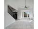 Open entryway area featuring tiled flooring, a staircase with black railings and a ceiling fan at 1428 E Las Palmaritas Dr, Phoenix, AZ 85020