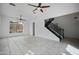 Large living room with neutral tile flooring, ceiling fans, and large view windows by the staircase at 1428 E Las Palmaritas Dr, Phoenix, AZ 85020