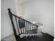 Modern staircase with a black handrail and chandelier overhead at 1428 E Las Palmaritas Dr, Phoenix, AZ 85020