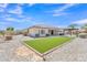 Wide backyard showcasing the patio, artificial lawn, landscaping, and the home's design in a harmonious layout at 14612 W Edgemont Ave, Goodyear, AZ 85395