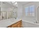 Bright bathroom showcasing a soaking tub, shower, and wood cabinets for plenty of storage space at 14612 W Edgemont Ave, Goodyear, AZ 85395