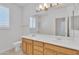 Bright bathroom featuring a double sink vanity, large mirror, and neutral tile flooring at 14612 W Edgemont Ave, Goodyear, AZ 85395