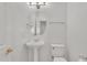 Powder room featuring a pedestal sink, toilet, and decorative mirror with a towel bar at 14612 W Edgemont Ave, Goodyear, AZ 85395