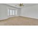 Spacious bedroom with neutral carpet, ceiling fan, and a bay window with plantation shutters at 14612 W Edgemont Ave, Goodyear, AZ 85395