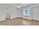 Large primary bedroom with wood flooring, ceiling fan and white window shutters at 14612 W Edgemont Ave, Goodyear, AZ 85395