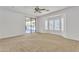 Bright bedroom with neutral carpet, ceiling fan, and a sliding glass door to the backyard at 14612 W Edgemont Ave, Goodyear, AZ 85395