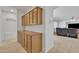 Hallway with built-in cabinets and drawers, and tile floors leads to the living room at 14612 W Edgemont Ave, Goodyear, AZ 85395