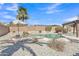 A backyard swimming pool with a waterfall feature, pergola, landscaping, and patio umbrella at 14612 W Edgemont Ave, Goodyear, AZ 85395