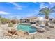 Backyard pool featuring a rock waterfall, pergola, and lush landscaping under a clear blue sky at 14612 W Edgemont Ave, Goodyear, AZ 85395