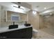 Modern bathroom featuring double black sinks, stylish lighting, and a glass-enclosed shower with beautiful stone-look tiles at 1509 W Kiowa Ave, Mesa, AZ 85202