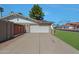 Long driveway leading to a two-car garage with a private gate and mature landscaping at 1509 W Kiowa Ave, Mesa, AZ 85202