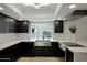 Modern kitchen with stainless steel farmhouse sink, black cabinets, and quartz countertops at 1509 W Kiowa Ave, Mesa, AZ 85202