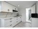 Bright kitchen with white cabinets, a black range hood, white marble-look countertops and backsplash at 1509 W Kiowa Ave, Mesa, AZ 85202