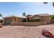 Inviting single-story home featuring a desert landscape with mature palm trees and a two-car garage at 15479 W Whitton Ave, Goodyear, AZ 85395