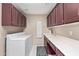 Well-lit laundry room with storage cabinets, sink, countertop, washer and dryer at 15479 W Whitton Ave, Goodyear, AZ 85395