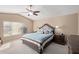 Spacious main bedroom featuring a ceiling fan, side tables, and a window for natural light at 15479 W Whitton Ave, Goodyear, AZ 85395